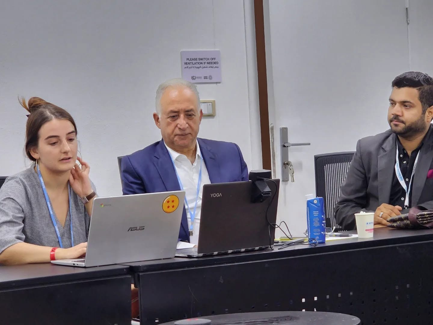 Delegates working at laptops during a session at COP27.